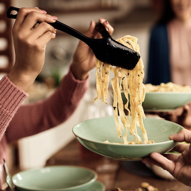 image of pasta with a hand scooping it up